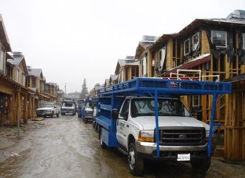 Residential plumbing — Marrone trucks at a custom-home construction site